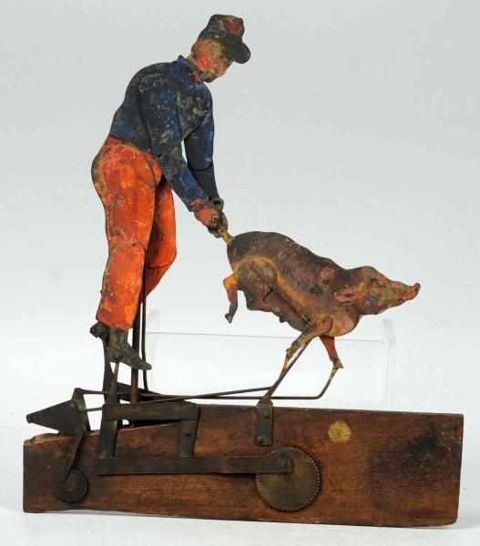 Appraisal: Early Tin Wood Man With Pig Whirligig Toy Depicts a