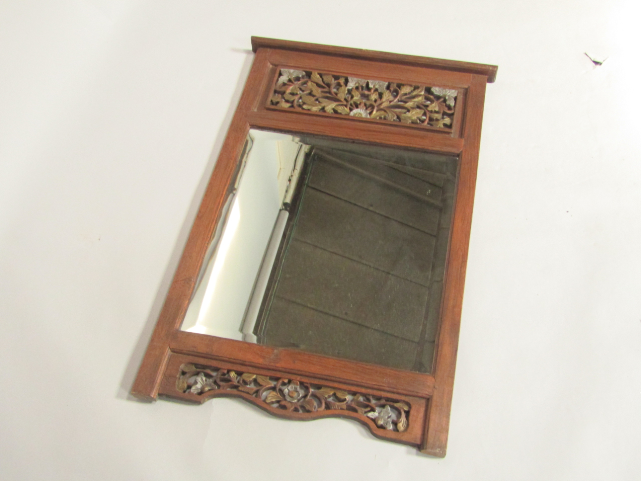 Appraisal: A Far Eastern hardwood wall mirror with floral and foliate