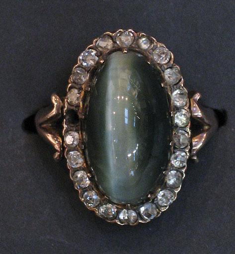 Appraisal: A CHRYSOBERYL CATS EYE AND DIAMOND-SET CLUSTER RING the central