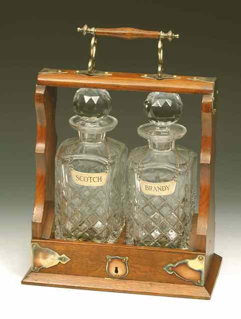 Appraisal: A TWO BOTTLE MAHOGANY TANTALUS with gilt brass mounts and