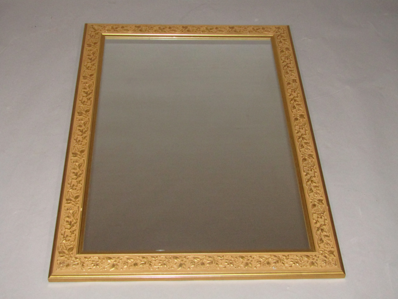 Appraisal: A rectangular gilt wall mirror moulded with a border of