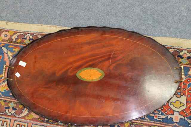 Appraisal: A MAHOGANY OVAL TRAY with wavy galleried edge and brass