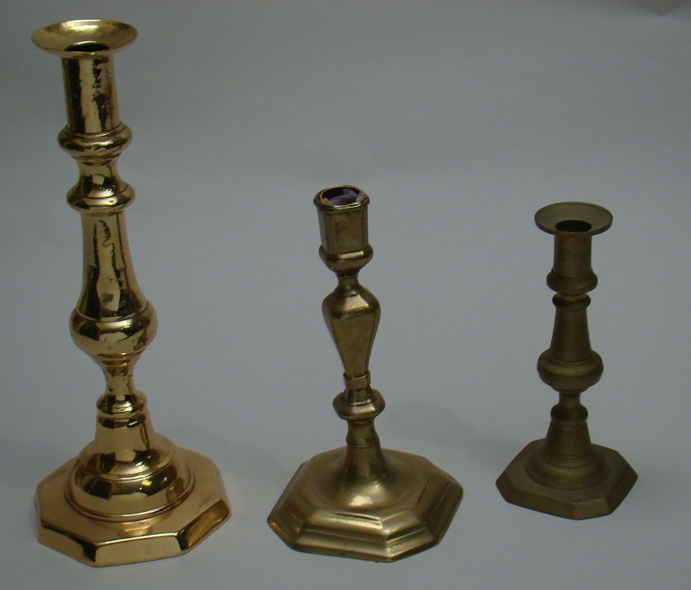 Appraisal: THREE BRASS CANDLESTICKS Two th century push-up candlesticks heights dented