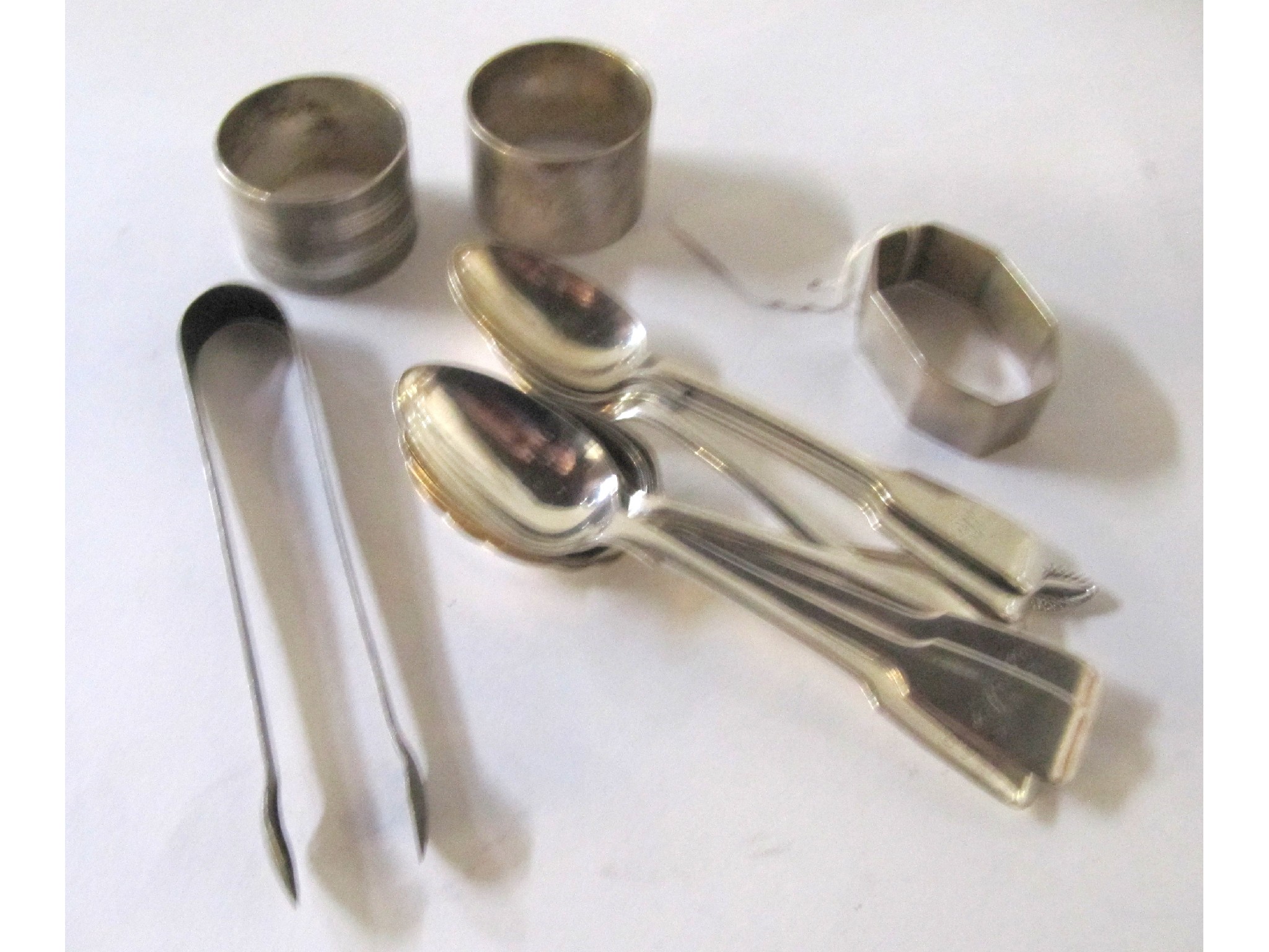 Appraisal: A lot comprising three silver napkin rings silver teaspoons and