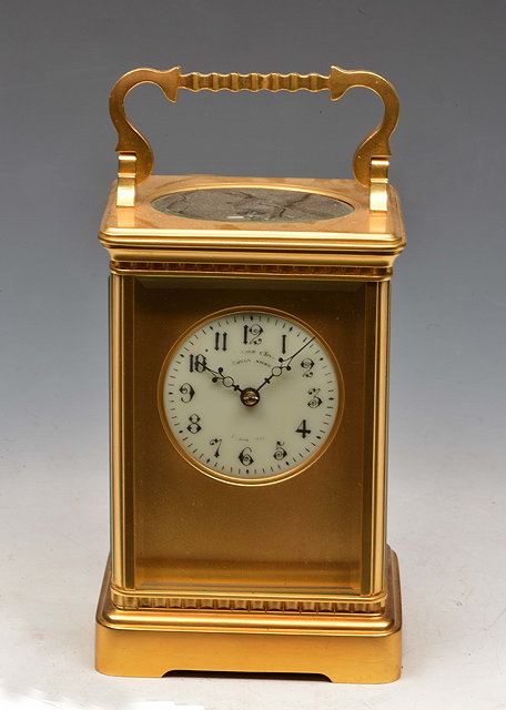 Appraisal: A FRENCH CARRIAGE CLOCK the gilt mask and circular enamel