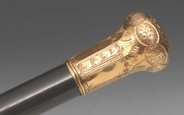 Appraisal: AN EBONISED WALKING STICK with an unmarked gold coloured metal