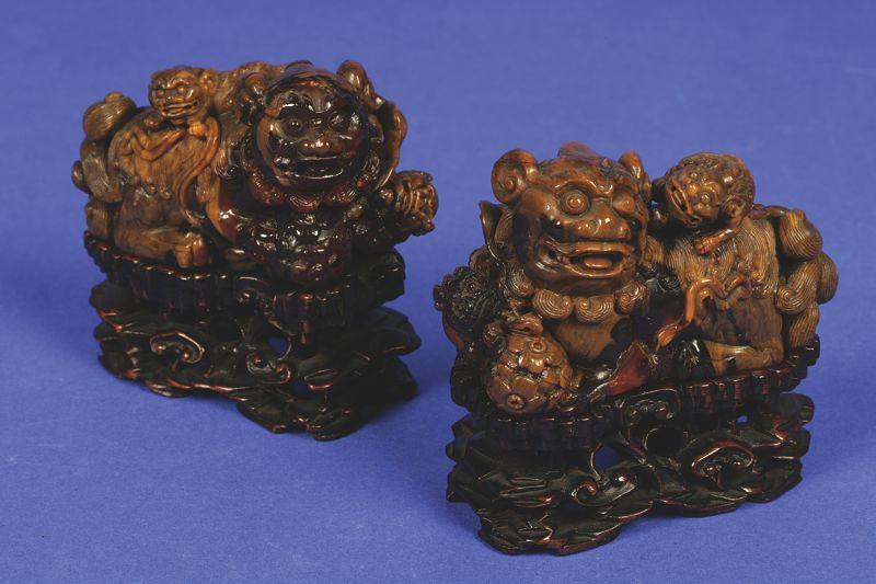 Appraisal: A PAIR OF CHINESE ROOT AMBER LION GROUPS each carved