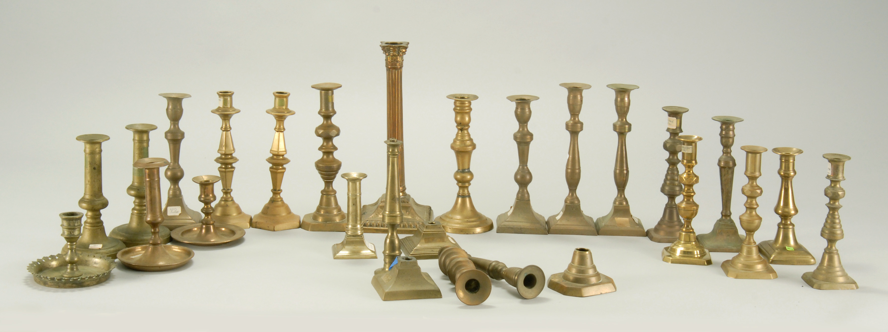 Appraisal: TWENTY-THREE BRASS AND BELL METAL CANDLESTICKS Forms vary Heights from