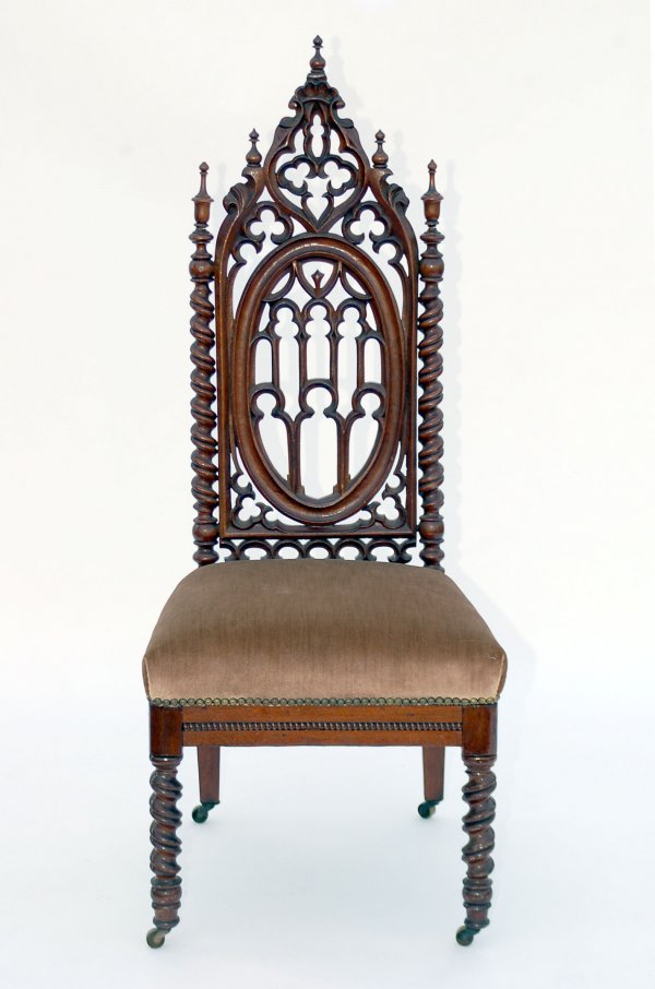 Appraisal: Side chair Walnut frame intricate carvedf gothic back Brass casters