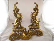 Appraisal: A pair of brass winged lion firedogs with iron stays