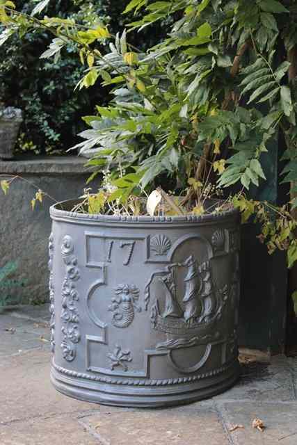 Appraisal: A PAIR OF COMPOSITE CYLINDRICAL FAUX LEAD PLANTERS with mermaid