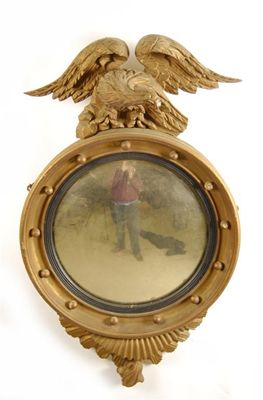 Appraisal: A Regency style giltwood convex mirror with an ebonised slip