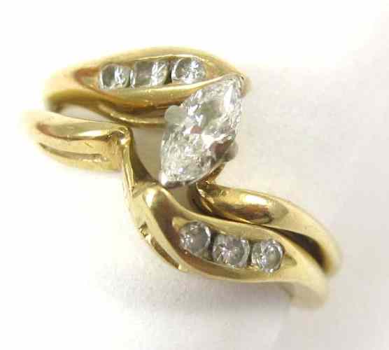 Appraisal: DIAMOND AND FOURTEEN KARAT GOLD RING SET the ring guard