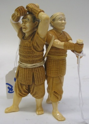 Appraisal: TWO JAPANESE HAND CARVED IVORY AND WOOD FIGURES samurai wearing