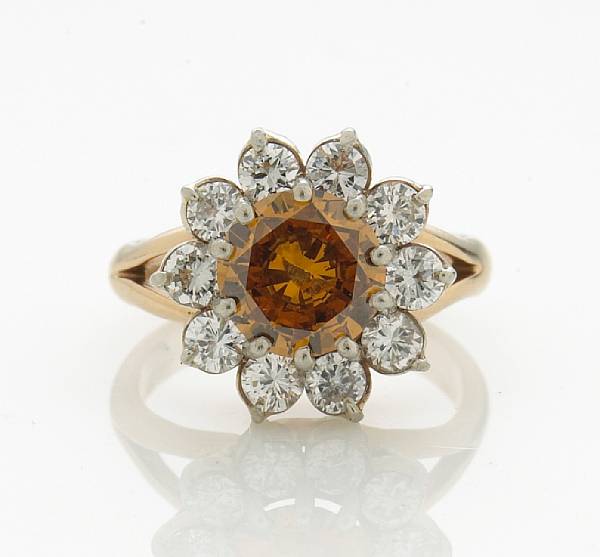 Appraisal: A colored diamond and diamond cluster ring centering an orange-brown