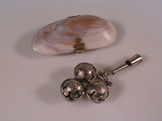 Appraisal: A mussel shell purse and a white metal rattle