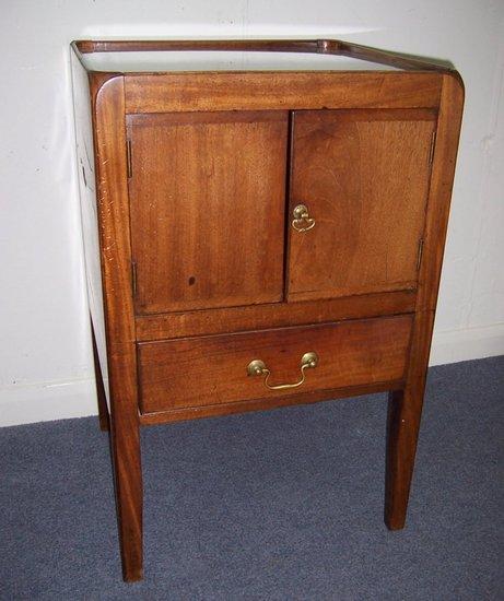 Appraisal: A George III mahogany commode fitted cupboard doors over a