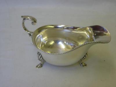 Appraisal: A SAUCE BOAT of oval form with gadrooned rim leaf