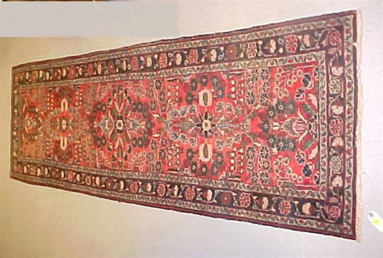 Appraisal: Dergazine Oriental runner red field black border three floral medallions