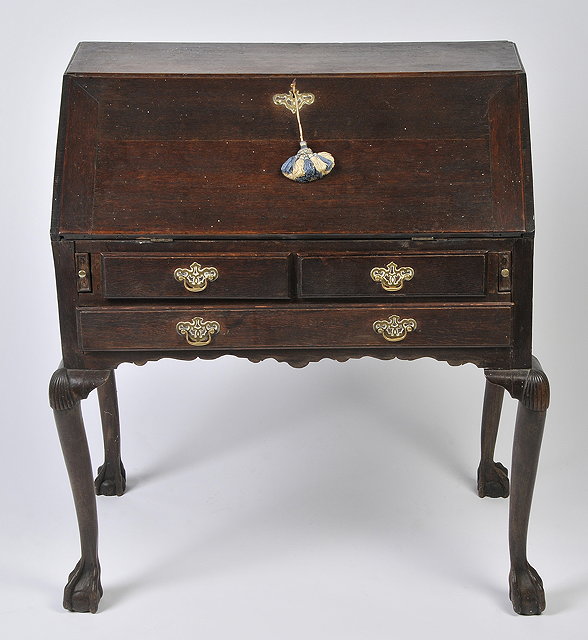 Appraisal: A GEORGE III OAK BUREAU raised on carved cabriole legs