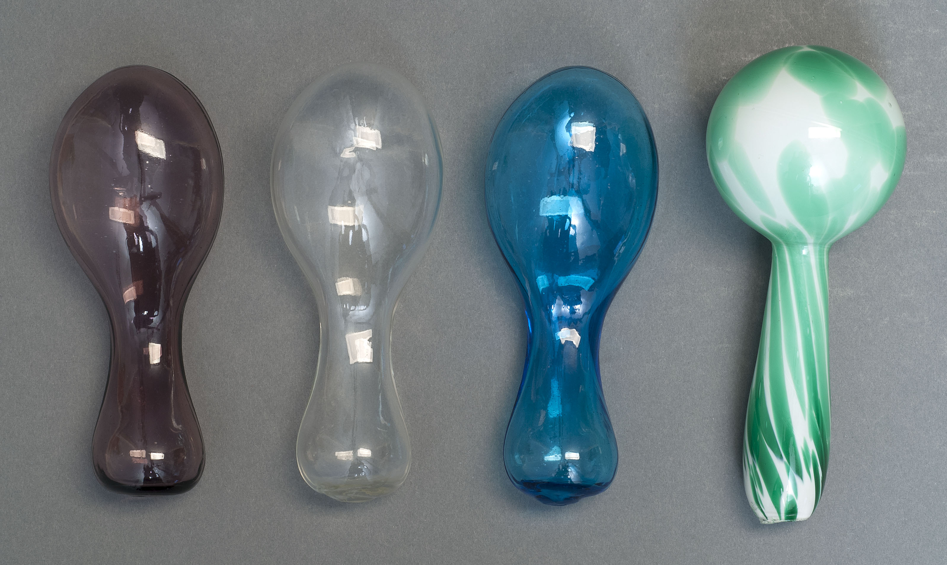 Appraisal: FOUR BLOWN GLASS SOCK DARNERS th CenturyIncludes a Sandwich Glass