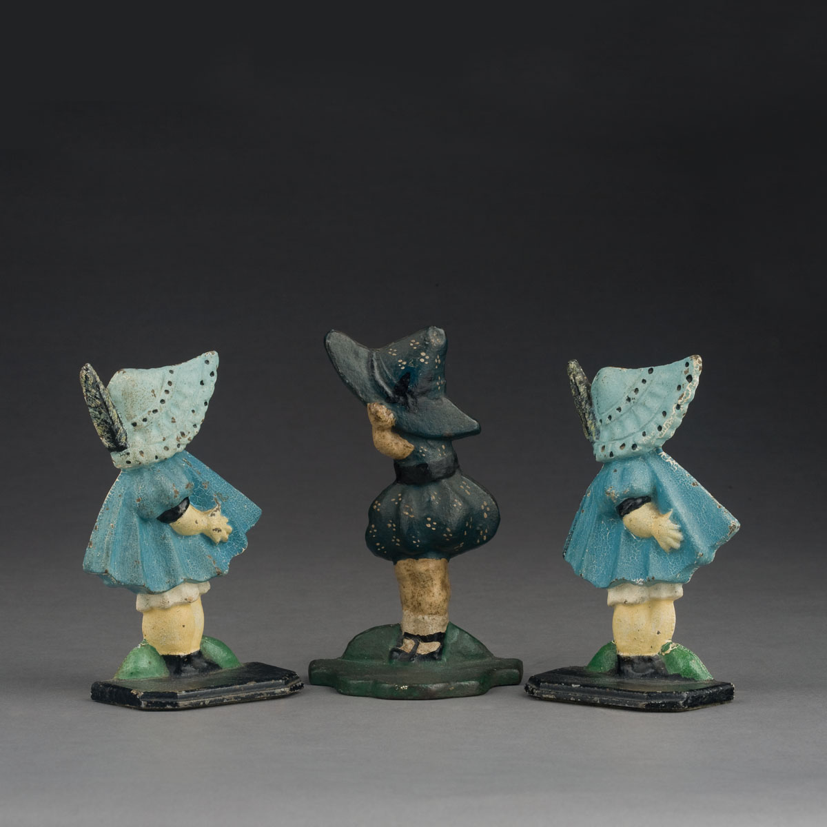 Appraisal: THREE CAST-IRON SUNBONNET BABY DOORSTOPS Height inches