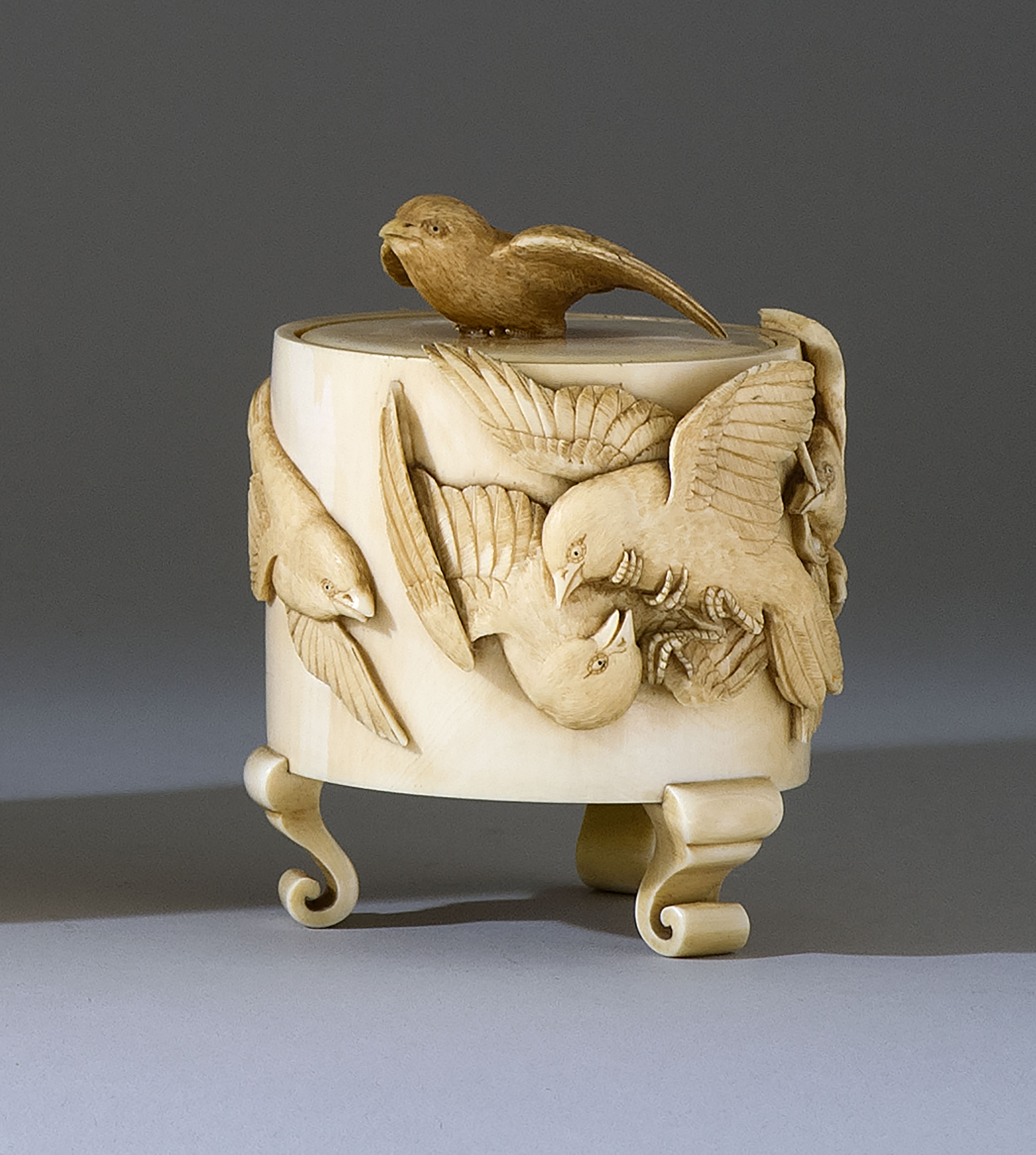 Appraisal: IVORY BOX Meiji PeriodIn three-footed cylinder form with high-relief carving