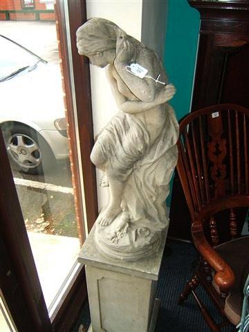 Appraisal: A composite stone statue of a maiden seated on a