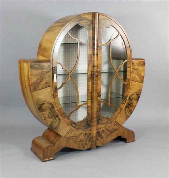 Appraisal: An Art Deco figured walnut display cabinet of stylised circular