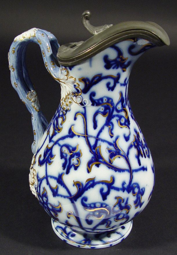 Appraisal: Victorian flow blue china jug with pewter mount and grapevine