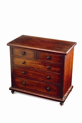 Appraisal: A Victorian mahogany miniature chest with turned handles and feet