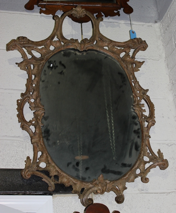 Appraisal: ROCOCO STYLE CARVED WOOD OVAL MIRROR the pierced frame with