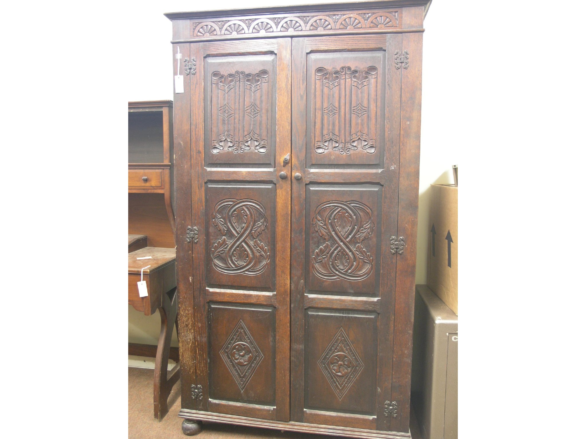 Appraisal: A solid dark oak wardrobe enclosed by a pair of