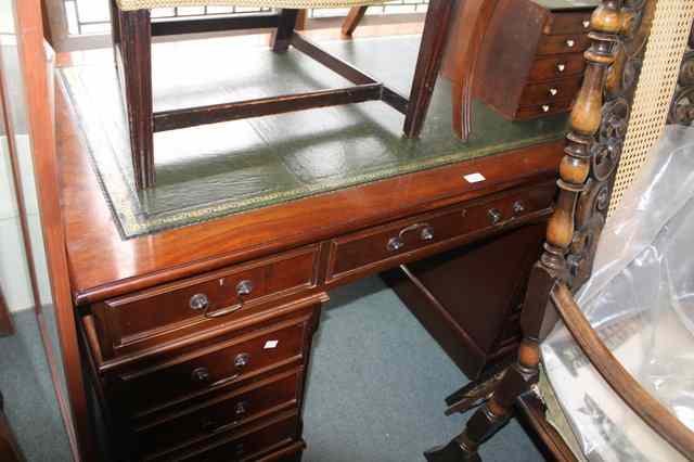 Appraisal: A REPRODUCTION MAHOGANY PEDESTAL DESK fitted with an arrangement of