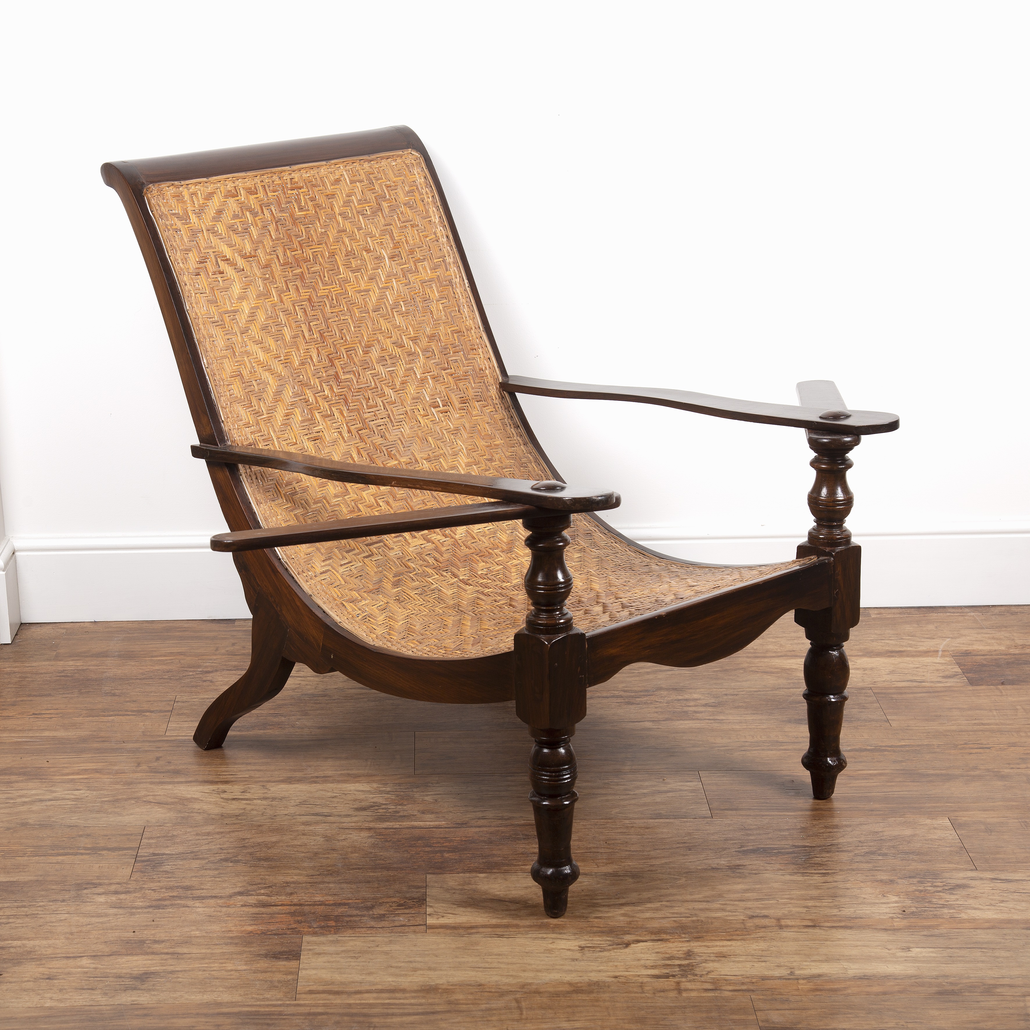 Appraisal: Plantation chairhaving a stained wood frame and woven rattan seat