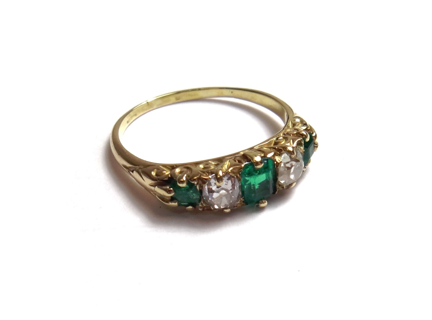 Appraisal: A gold emerald and diamond set five stone ring mounted