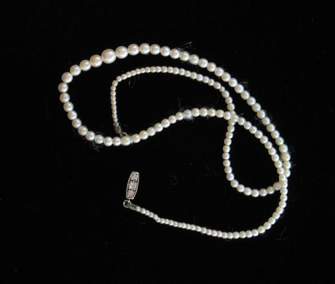 Appraisal: A GRADUATED STRING OF PEARLS the rectangular clasp set with