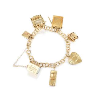 Appraisal: A Gold Charm Bracelet Featuring seven charms crafted out of