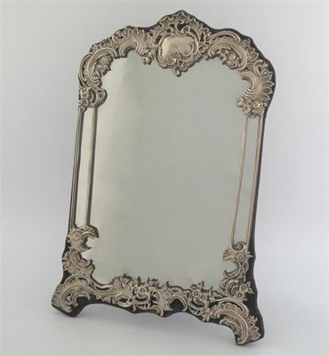 Appraisal: An Edwardian mounted mirror embossed scrolling decoration vacant cartouche velvet