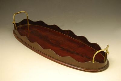 Appraisal: A mahogany oblong galleried tray with brass carrying handles in