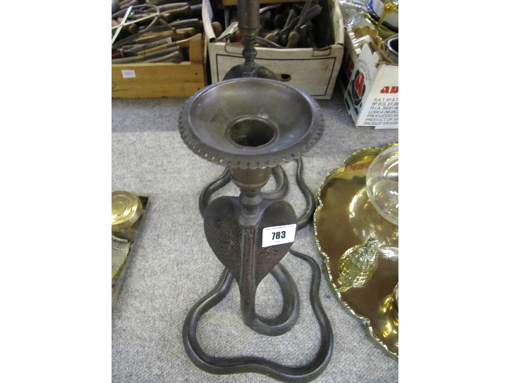 Appraisal: A pair of metal 'snake charmer' candlesticks