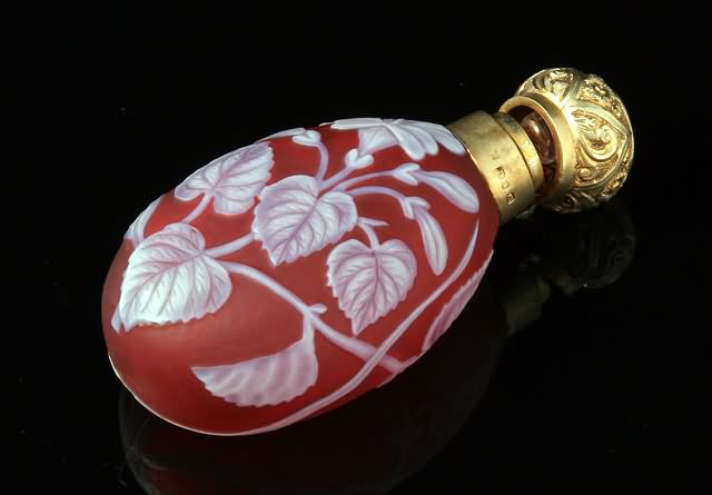 Appraisal: Floral design in white on ruby with butterfly silver gilt