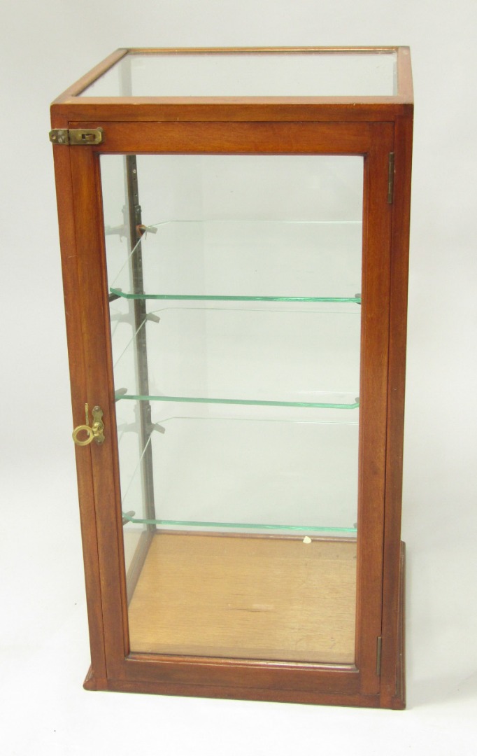 Appraisal: A mahogany shop display case of rectangular sections enclosing three