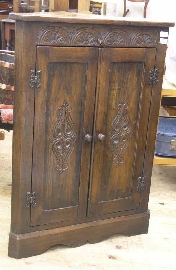 Appraisal: A reproduction solid dark oak corner cupboard floor standing enclosed