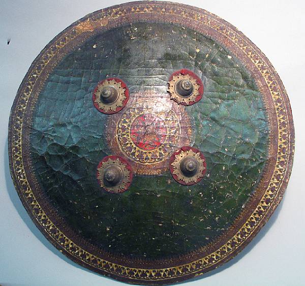 Appraisal: An Indian painted leather shield The circular shield fitted with