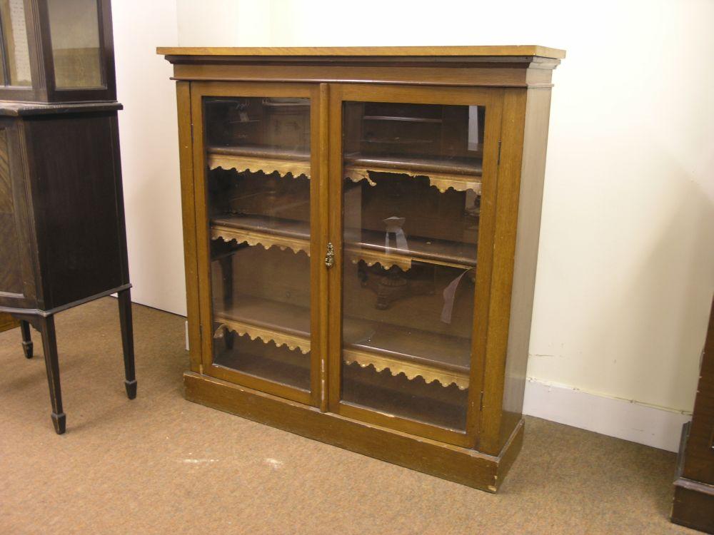 Appraisal: A light oak bookcase three shelves enclosed by a pair