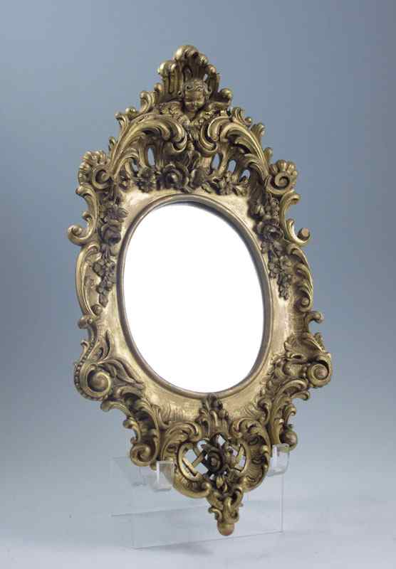 Appraisal: DIMINUTIVE FRENCH ORNATELY CARVED WOOD MIRROR Oval glass surmounted by