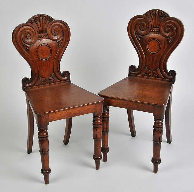 Appraisal: A PAIR OF VICTORIAN OAK HALL CHAIRS with carved scrolling