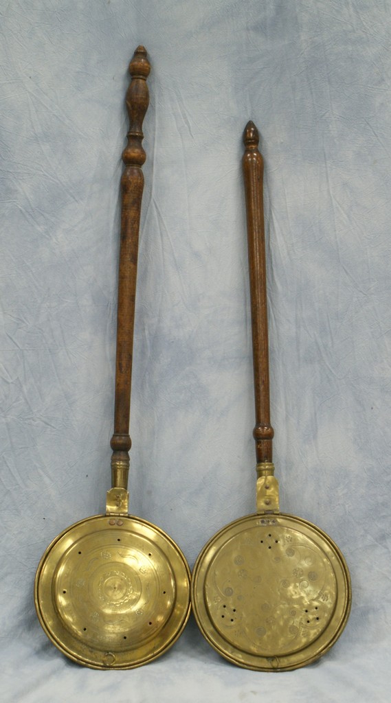 Appraisal: engraved brass bed warmers turned wooden handles th c longest