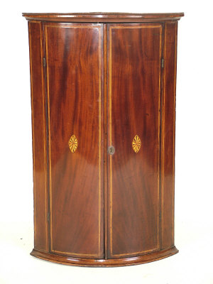 Appraisal: A George III bowfront mahogany corner cabinet circa the crossbanded